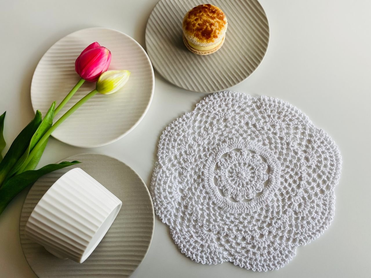 relax-atmosphere Cozy table setup with tulips, pastries, and a decorative lace mat for a serene ambiance.